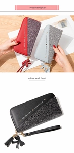 Detail view of contrast stitching patchwork wallets with gold studs and tassel charms