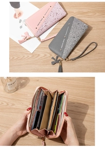 Detail of pink and gray patchwork long wallet featuring bow tassel and multi-slot interior
