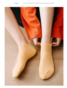 Detail of yellow cotton ankle socks with anti-slip heel and embroidery on wood floor