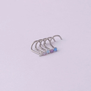 Five 20G titanium steel nose studs with 2mm multi-color opal stones on pink background