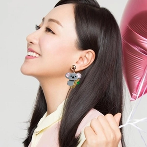 Cute koala with bamboo earrings in gold finish worn by model in a studio setting