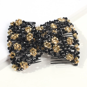 Detailed view of handmade black and gold beaded magic hair comb with a bow design