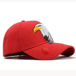 Detail of red baseball cap featuring intricate eagle head embroidery and leaf patterns