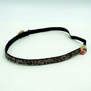 Detail of dark resin rhinestone headband featuring silver sequins and protective ear buttons