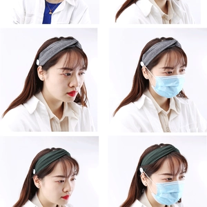 Détail du bandeau tricoté avec boutons pour fixer les masques et protéger les oreilles