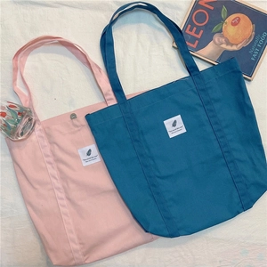 Minimalist canvas tote bags in pink and blue colors with double straps and magnetic closure