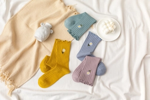 Detailed view of Morandi color cotton socks featuring daisy embroidery and ruffled edges