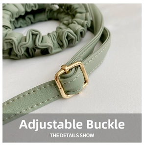 Detail of light green faux leather strap with gold adjustable buckle and white stitching