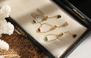 Detail of adjustable chain rings with emerald, ruby, and onyx stones and heart charms