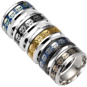 Macro shot of stainless steel rings with colorful glitter inlay and skull patterns