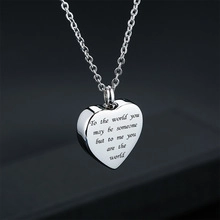 Silver heart cremation urn necklace with sentimental engraving on dark background