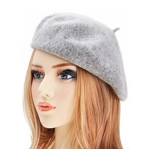 Close-up detail of light gray cashmere-style beret featuring fine wool texture and top stem