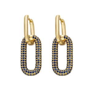 Dettaglio di orecchini dorati con cristalli blu incastonati a pavé in design ovale