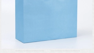 Detailed base shot of a durable light blue paper shopping bag with precise folding finish