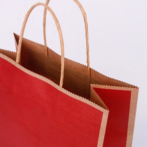 Detailed macro view of the sturdy brown twisted paper handles and red shopping bag rim