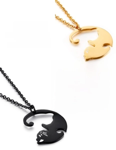 Gros plan sur des pendentifs chat en finitions or et noir avec design creux détaillé