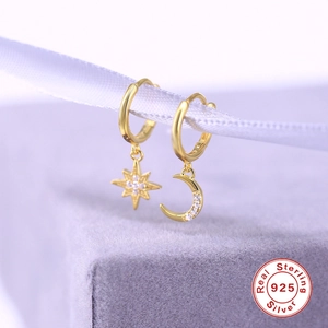 Asymmetric S925 sterling silver moon and star drop earrings on purple velvet background
