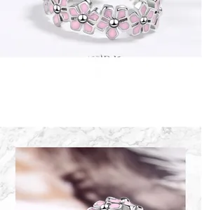 Detail of pink floral enamel ring with silver petals and intricate bead flower centers