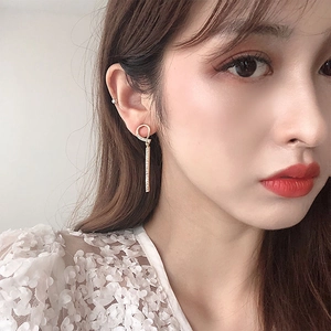 Close-up of elegant gold tassel earrings with pavé diamonds worn by a model