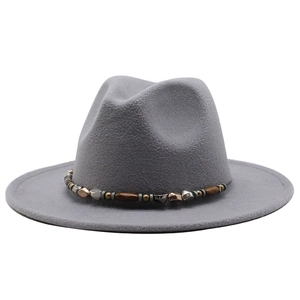 Close-up of grey wool fedora with bohemian beaded band featuring metallic and wood accents