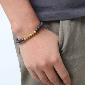 Men's minimalist black lava stone bead bracelet with polished gold steel accents