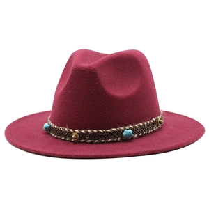 Close-up of wine red fedora hat with turquoise stone and golden stud woven band detail