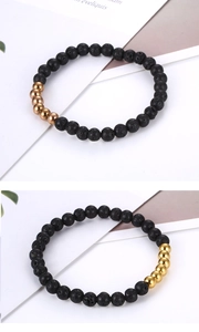 Detailed shot of black volcanic stone beads with polished gold accents on elastic bracelet