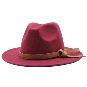 Close-up of wine red fedora wool hat featuring a brown faux leather band with a knot