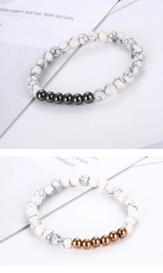Macro detail of white marble stone beads and polished metallic beads on elastic bracelet