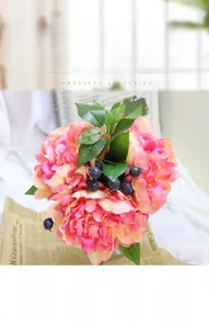 Close-up of artificial ranunculus bridal bouquet with blue berries and silk leaves
