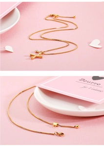 Detail of golden initial X necklace with zircon and adjustable sliding ball chain