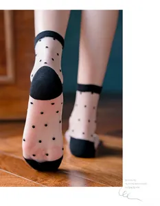 Close-up of sheer mesh socks with black polka dots and cotton reinforced heel detail