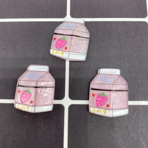 Close-up of pink resin strawberry milk carton bead with glitter for DIY crafts