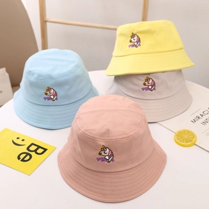 Détail de la broderie licorne et du texte 'Magic' sur les bobs en coton pastel
