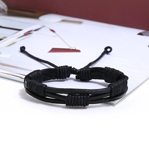 Close-up of black multilayer braided leather bracelet for men on a clean white desk