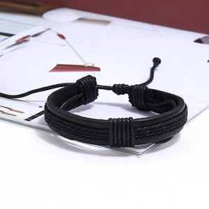 Close-up of black braided leather bracelet with adjustable knot on white table