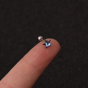 Macro shot of a pentagram iridescent crystal stud earring held on a fingertip