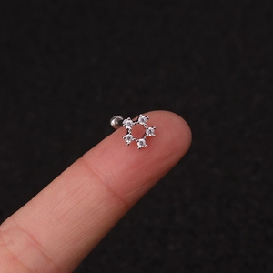 Macro shot of a 16G silver stainless steel cartilage stud with cubic zirconia stones