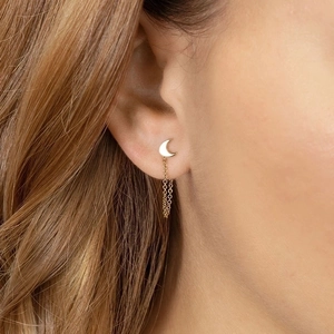 Golden moon tassel earrings with delicate short chain design worn by a female model