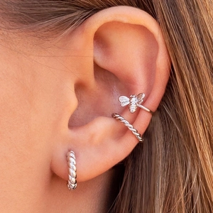 Silver 18k gold plated C-shaped ear cuffs and bee stud earrings set on a model's ear