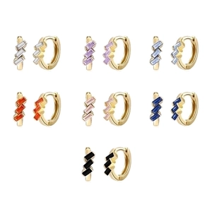 Close-up of gold huggie earrings with baguette-cut gemstones in various colors