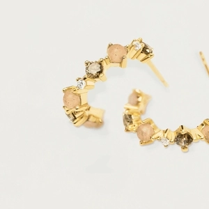C-shaped gold earrings with colorful zircon stones in a micro-pave setting