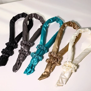 Five silk heatless hair curlers in black, grey, blue, gold, and beige with matching scrunchies