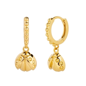 Detailed view of golden ladybug charms hanging from polished gold bead hoop earrings
