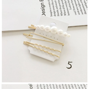 Detailed view of 3pcs pearl and gold geometric hair clips set on a card