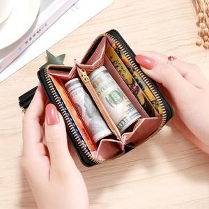 Women's short black PU leather wallet with pink interior, gold zipper and tassel detail