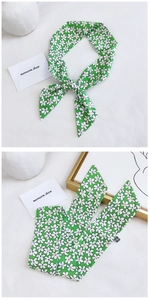 Detail of a narrow green floral silk scarf with small white flowers for hair or bag