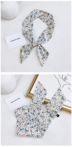 Macro detail of cotton linen scarf showing floral blue branch print and neat edge stitching