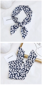 Detail showing navy blue floral cotton linen scarf used as a stylish hair tie bow