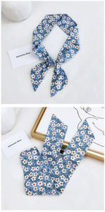 Detail of light blue floral cotton linen scarf with elegant drape and small flower print